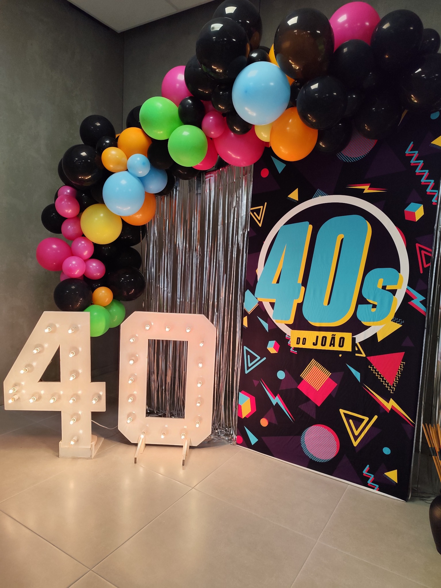 Cenário de aniversário dos 40 anos com balões coloridos e números iluminados