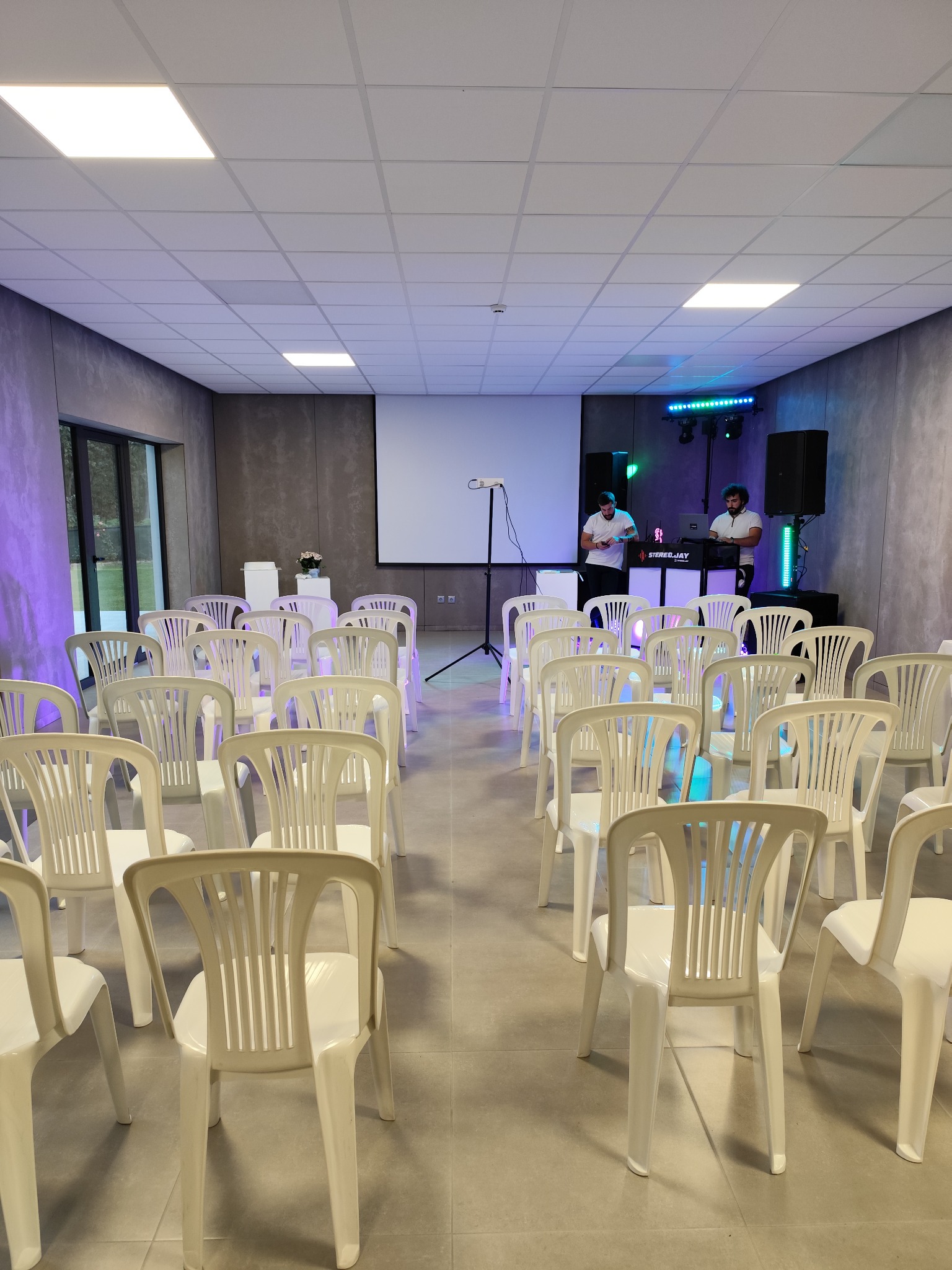 Sala com cadeiras organizadas em filas e uma zona de apresentação ao fundo