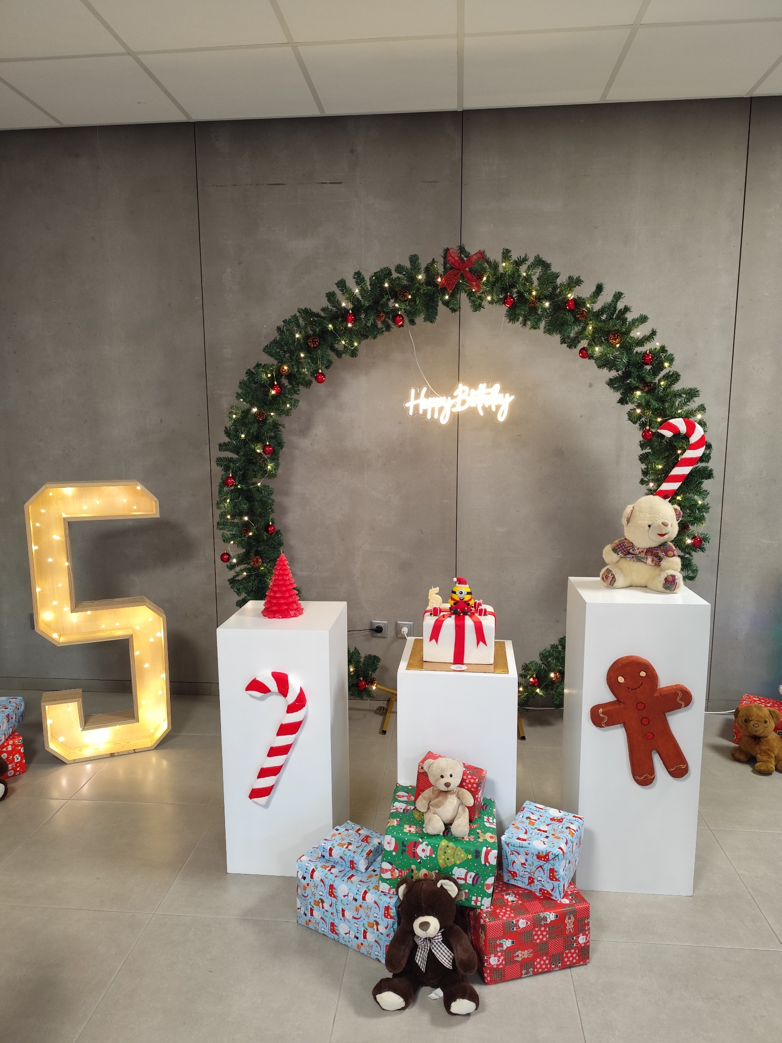 Decoração de aniversário com o número 5 iluminado, bolo e apontamentos natalícios